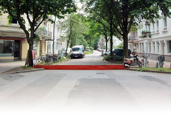 Ein roter Teppich liegt über der Straße an einer Kreuzung.