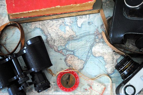 Alte Weltkarte mit Fernglas, Kompass und Kamera