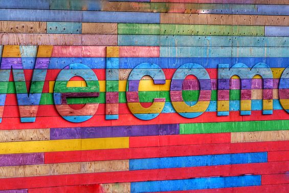 Eine farbige Holzwand mit dem Schriftzug "Welcome"