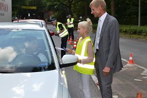 Martin Ochsenfarth von der Unfallkasse Nord und eine Schülerin im Gespräch mit einem Autofahrer